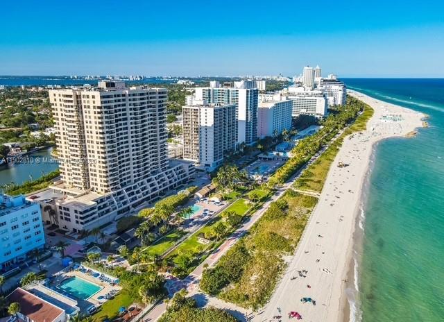 An aerial view shows high-rise apartment buildings along a sandy beach and the ocean — 2555 Collins Ave # 2200, Miami Beach FL 33140, MIAMI BEACH, FL