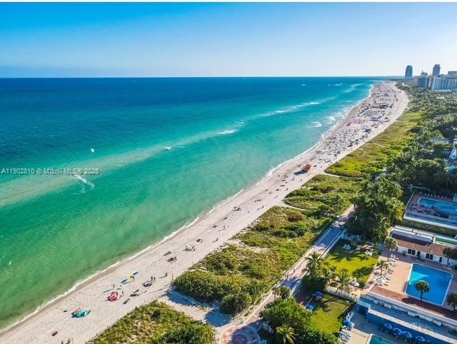 An aerial view shows a sandy beach along a turquoise ocean next to coastal buildings — 2555 Collins Ave # 2200, Miami Beach FL 33140, MIAMI BEACH, FL