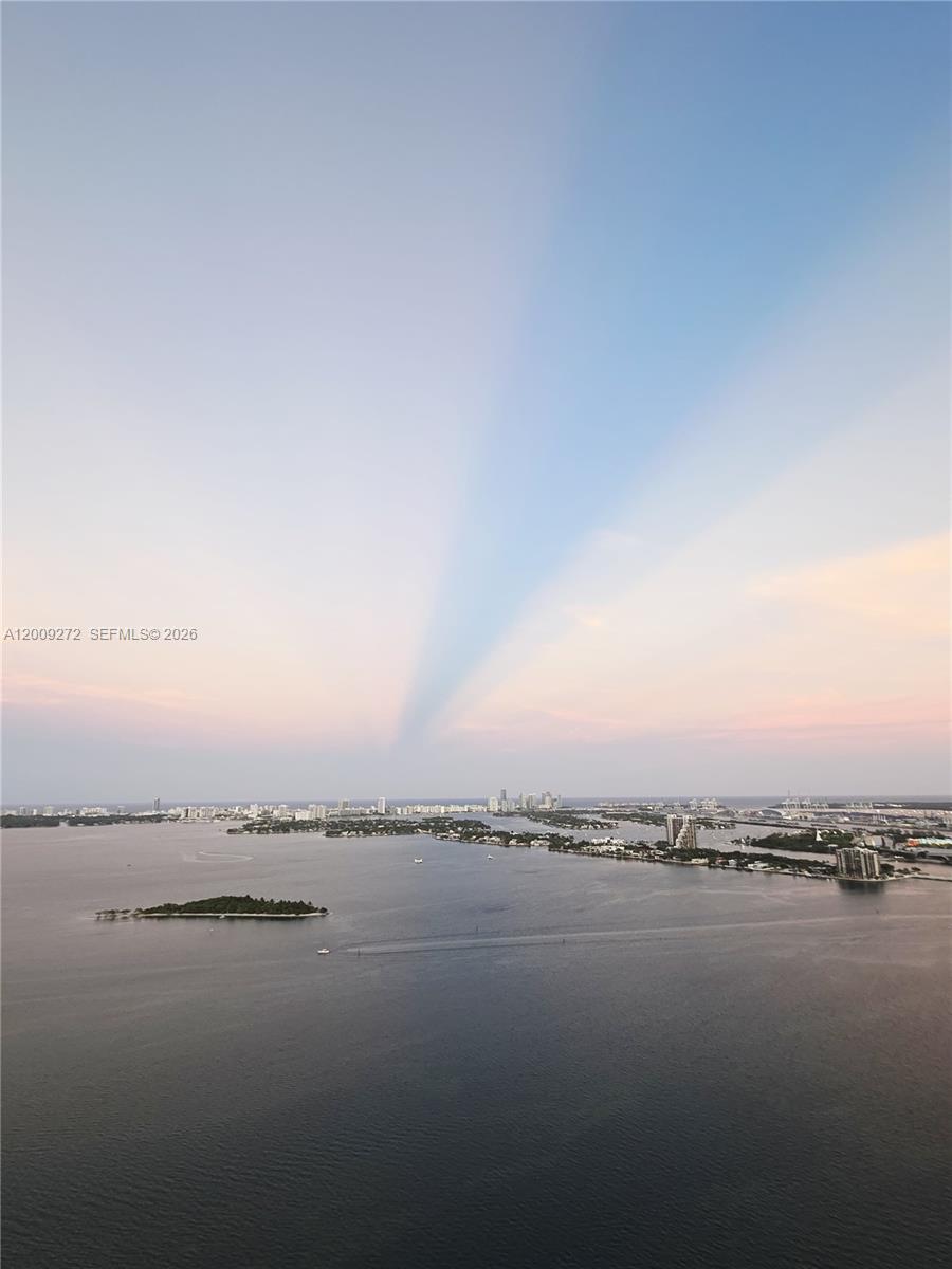 An aerial view shows a large body of water with islands and a distant city skyline — 700 NE 24 St # 3903, Miami FL 33137, MIAMI, FL