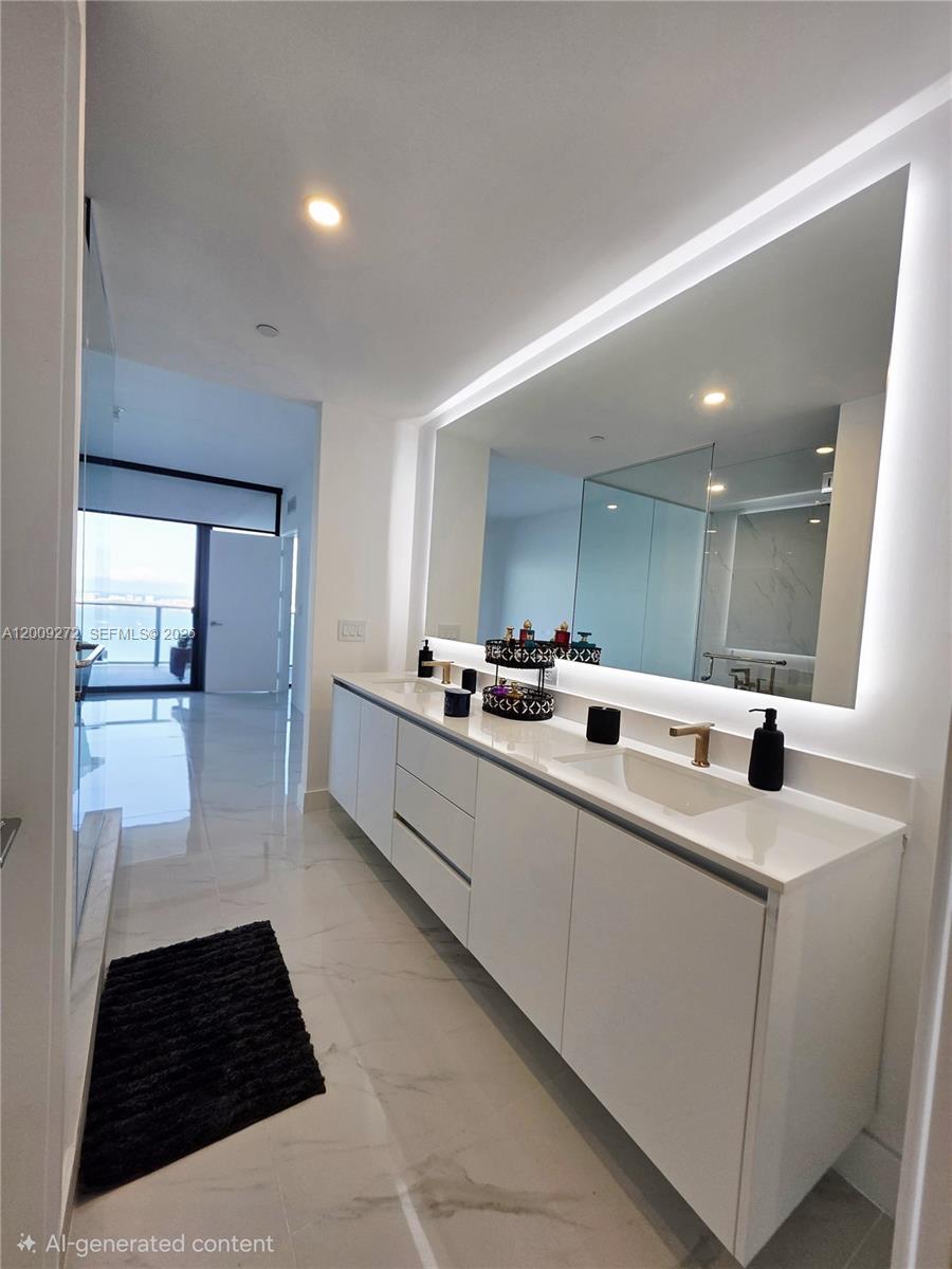 A modern bathroom features a white double vanity, large backlit mirror, and marble-style flooring — 700 NE 24 St # 3903, Miami FL 33137, MIAMI, FL