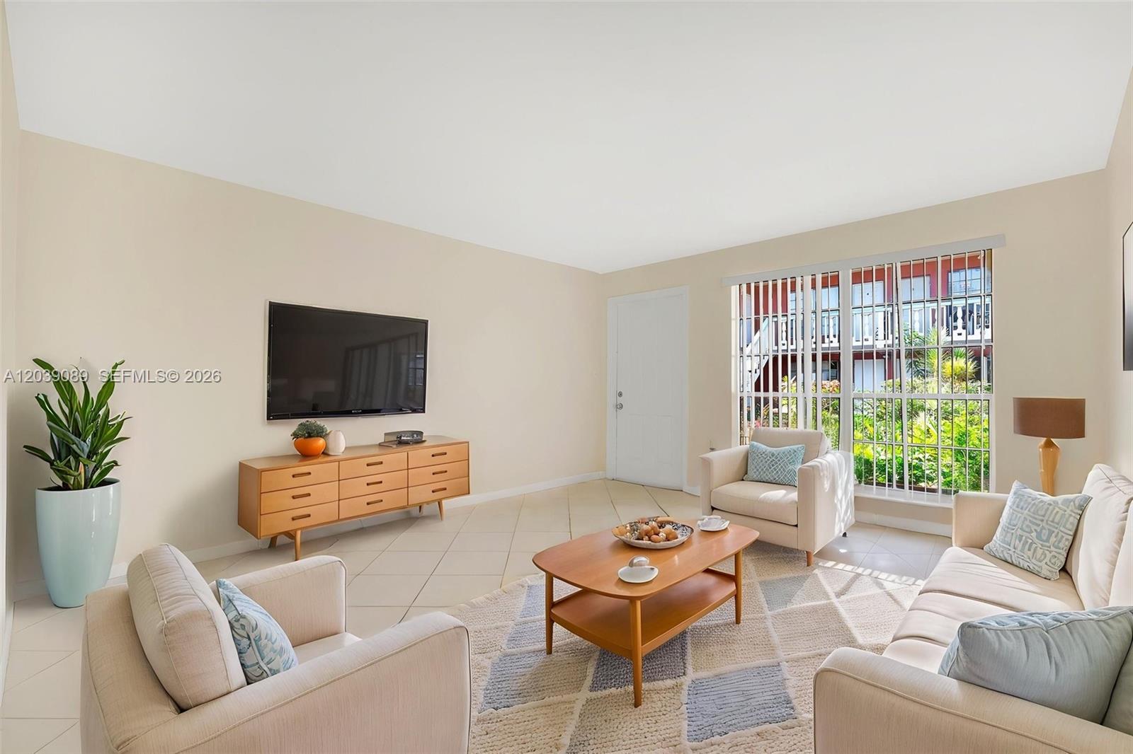 A living room features light tile floors, a television, a coffee table, and neutral seating — 2151 NW 64th Ave, Sunrise FL 33313, SUNRISE, FL