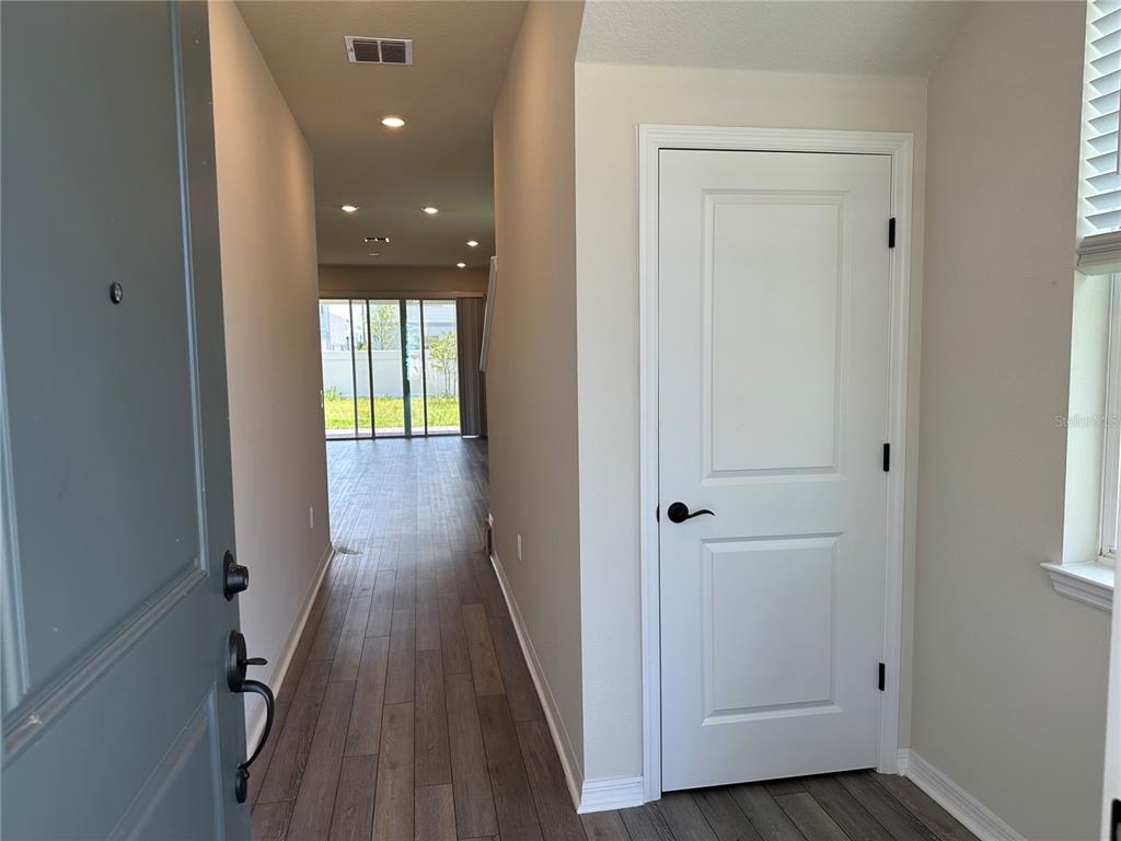 A view from an entryway looking down a hallway toward a living area with glass doors — 10355 PARKVIEW RESERVE LANE, ORLANDO, FL