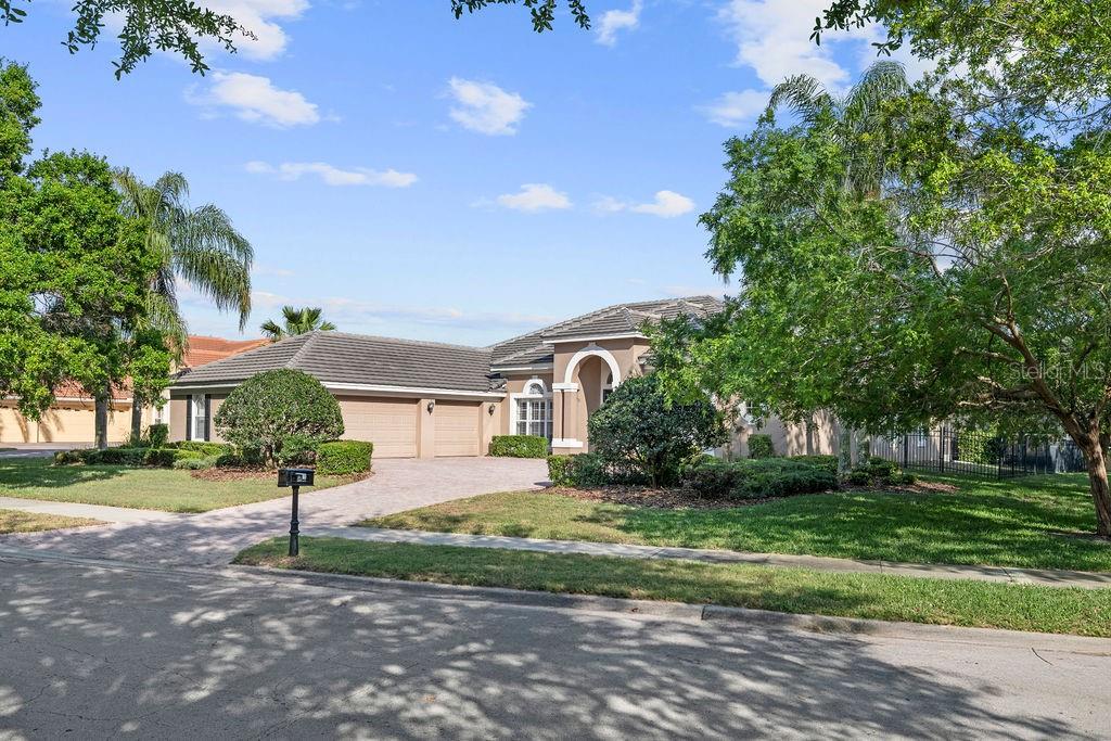 A single-story house with a brick driveway, a three-car garage, and a covered entryway — 2523 SAINT IGNATIUS COURT, ORLANDO, FL