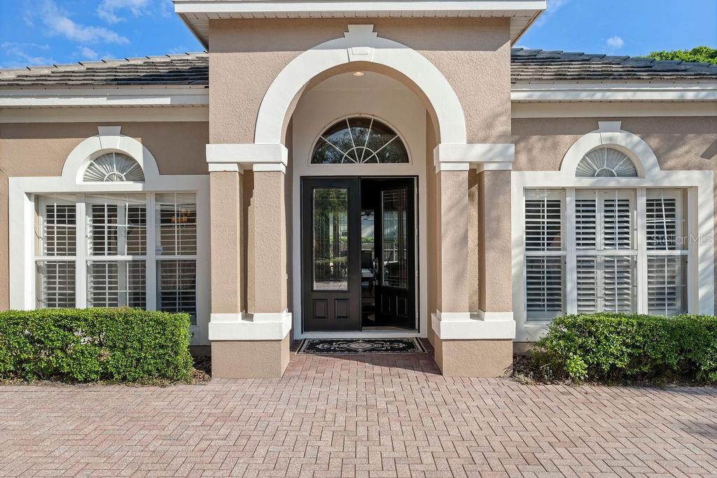 A formal living room features a tray ceiling, beige walls, and matching floral-patterned furniture — 2523 SAINT IGNATIUS COURT, ORLANDO, FL