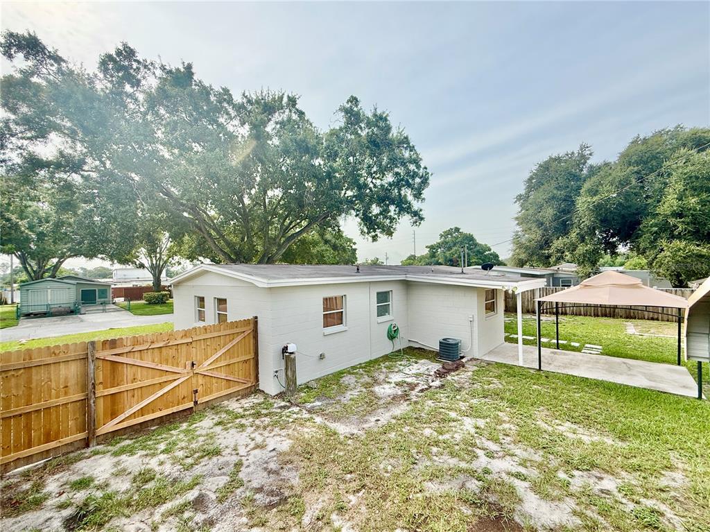 A single-story white house with a large tree in the front yard — 7810 FELICE AVENUE, TAMPA, FL