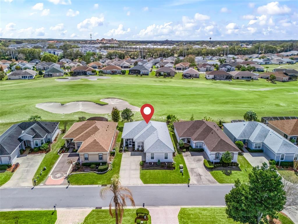 An aerial view shows a single-story house with a light roof overlooking a golf course — 11900 SE 178TH STREET, SUMMERFIELD, FL