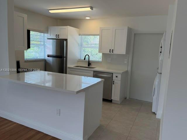 A modern kitchen features white cabinetry, stainless steel appliances, and a quartz-topped island — 3311 S Le Jeune Rd # 2, Coral Gables FL 33134, CORAL GABLES, FL