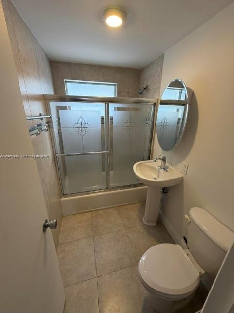 A bathroom features a pedestal sink, a toilet, and a shower-tub combo with sliding glass doors — 3311 S Le Jeune Rd # 2, Coral Gables FL 33134, CORAL GABLES, FL