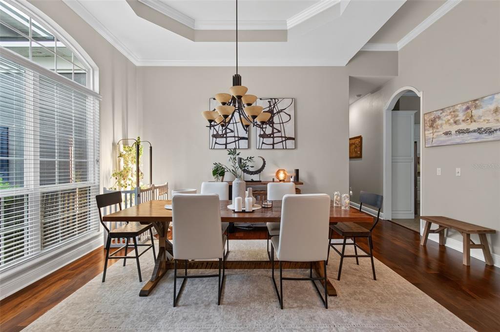 A dining room features a wooden table, upholstered chairs, a chandelier, and hardwood floors — 1326 SW 90TH STREET, GAINESVILLE, FL