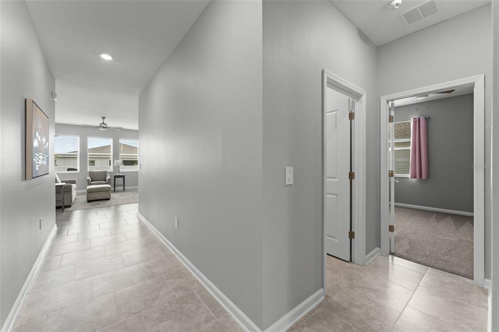 A tiled hallway leads to a living area with two doorways opening into adjacent rooms — 1795 ROSS HAMMOCK AVENUE, GROVELAND, FL