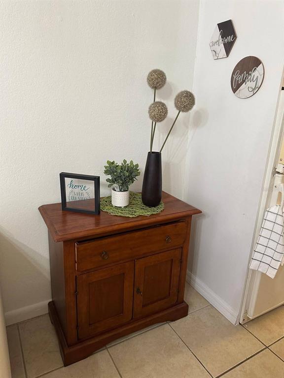 A wooden cabinet with a drawer and two doors sits in a corner with decor — 43420 HIGHWAY 27 UNIT 445, DAVENPORT, FL
