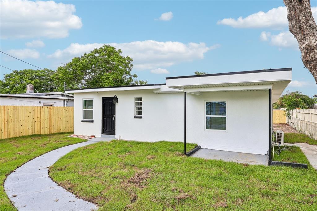 A white, single-story house with a black front door and a covered side porch — 918 FERNDELL ROAD, ORLANDO, FL