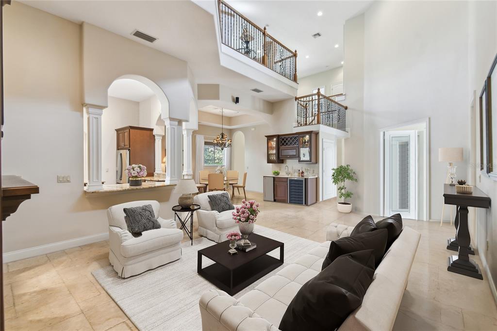 A spacious living room with high ceilings, tile floors, a wet bar, and a balcony overlook — 755 CRANES COURT, MAITLAND, FL