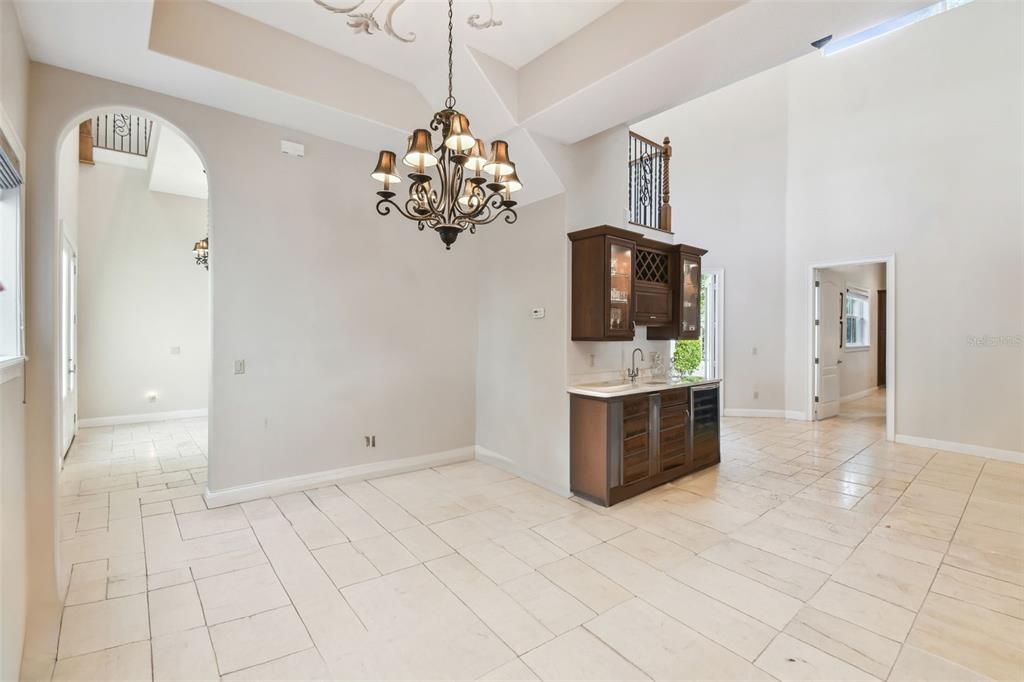A dining area with a chandelier, tile flooring, and a built-in wet bar cabinet — 755 CRANES COURT, MAITLAND, FL