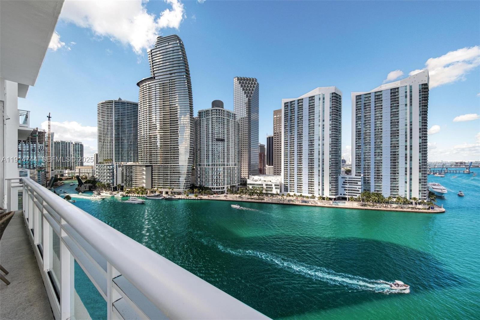 A balcony overlooks a turquoise bay with a skyline of modern high-rise buildings — 900 Brickell Key Blvd # 1403, Miami FL 33131, MIAMI, FL