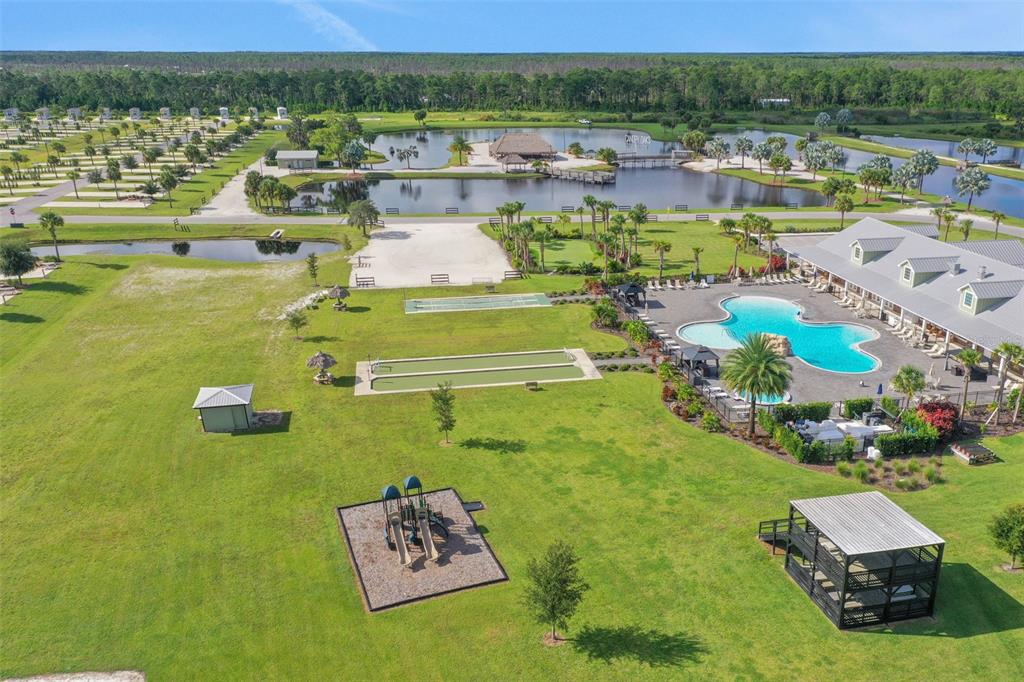 An aerial view shows a resort with a swimming pool, playground, and multiple ponds — 0 HIGHWAY 630 E UNIT 313, LAKE WALES, FL