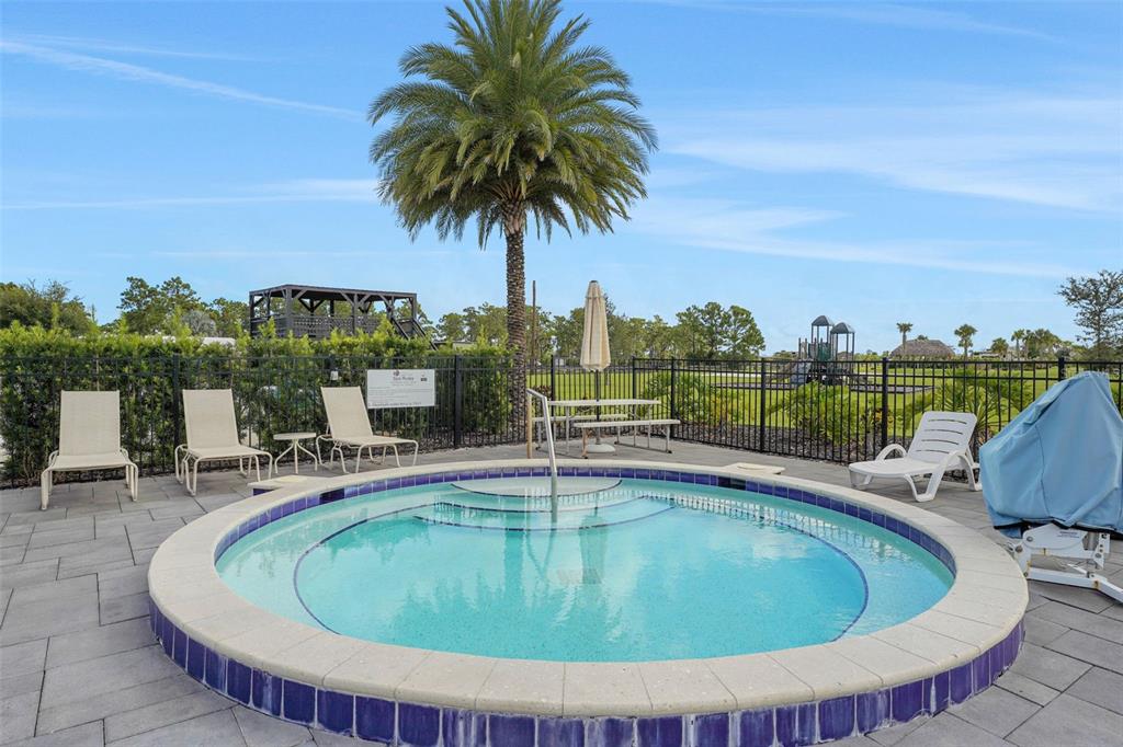 A circular hot tub sits on a paved patio with lounge chairs and a palm tree — 0 HIGHWAY 630 E UNIT 313, LAKE WALES, FL