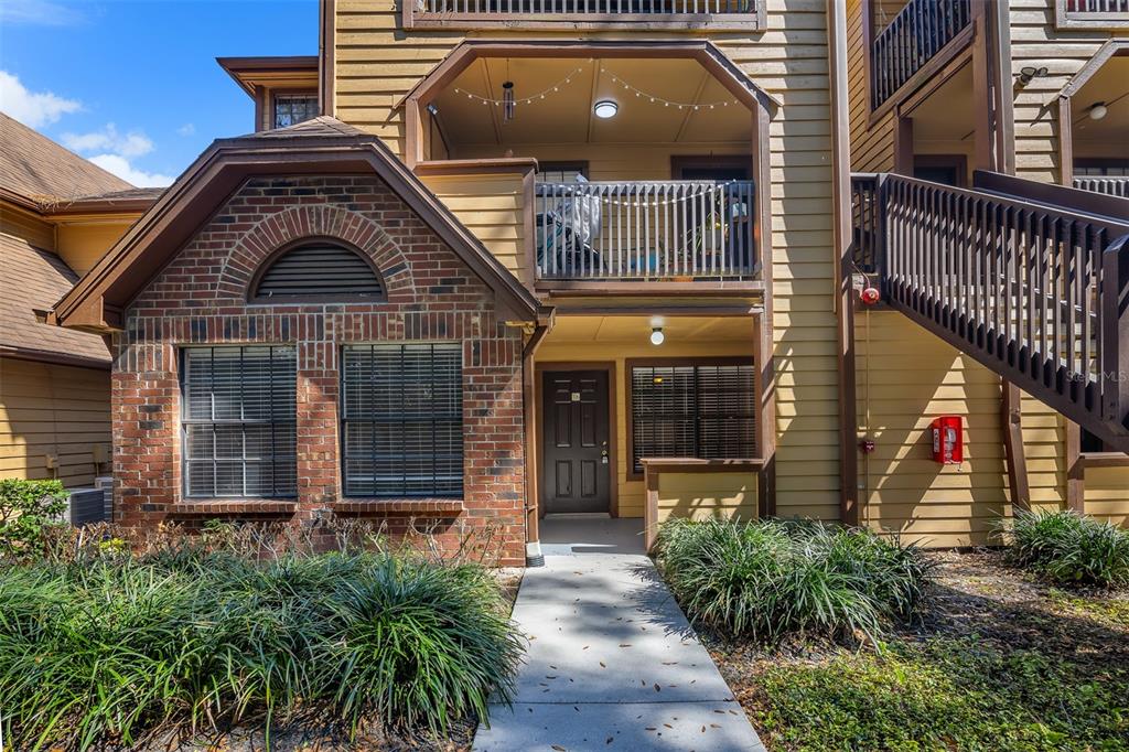 A two-story apartment building exterior featuring a brick facade, a balcony, and a front entrance — 485 FORESTWAY CIRCLE UNIT 106, ALTAMONTE SPRINGS, FL