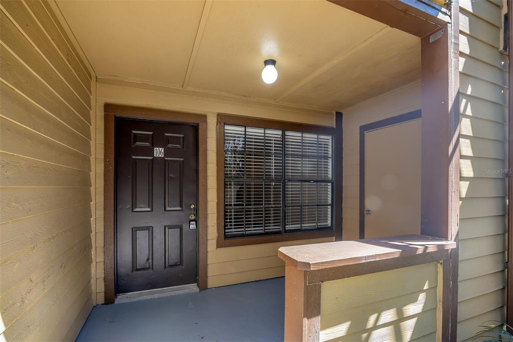 A covered entryway features a dark brown front door, a window, and a small porch — 485 FORESTWAY CIRCLE UNIT 106, ALTAMONTE SPRINGS, FL