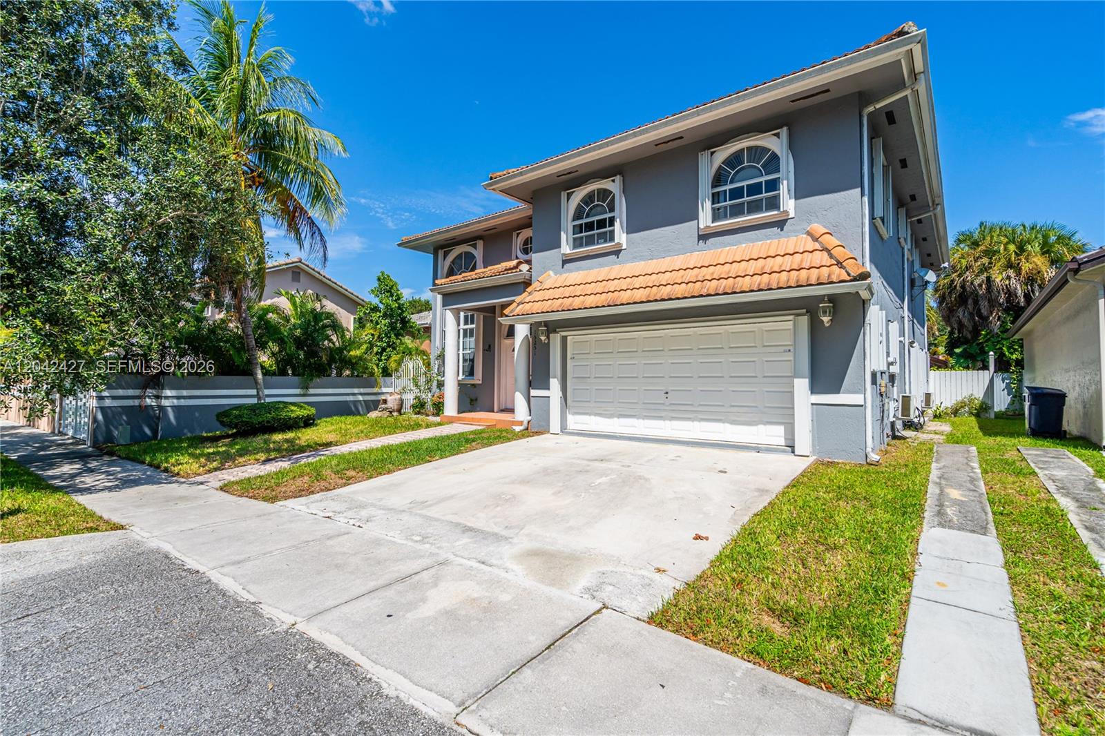 A two-story gray house features a white garage door and a terracotta-tiled roof — 15251 NW 89th Ave, Miami Lakes FL 33018, MIAMI LAKES, FL