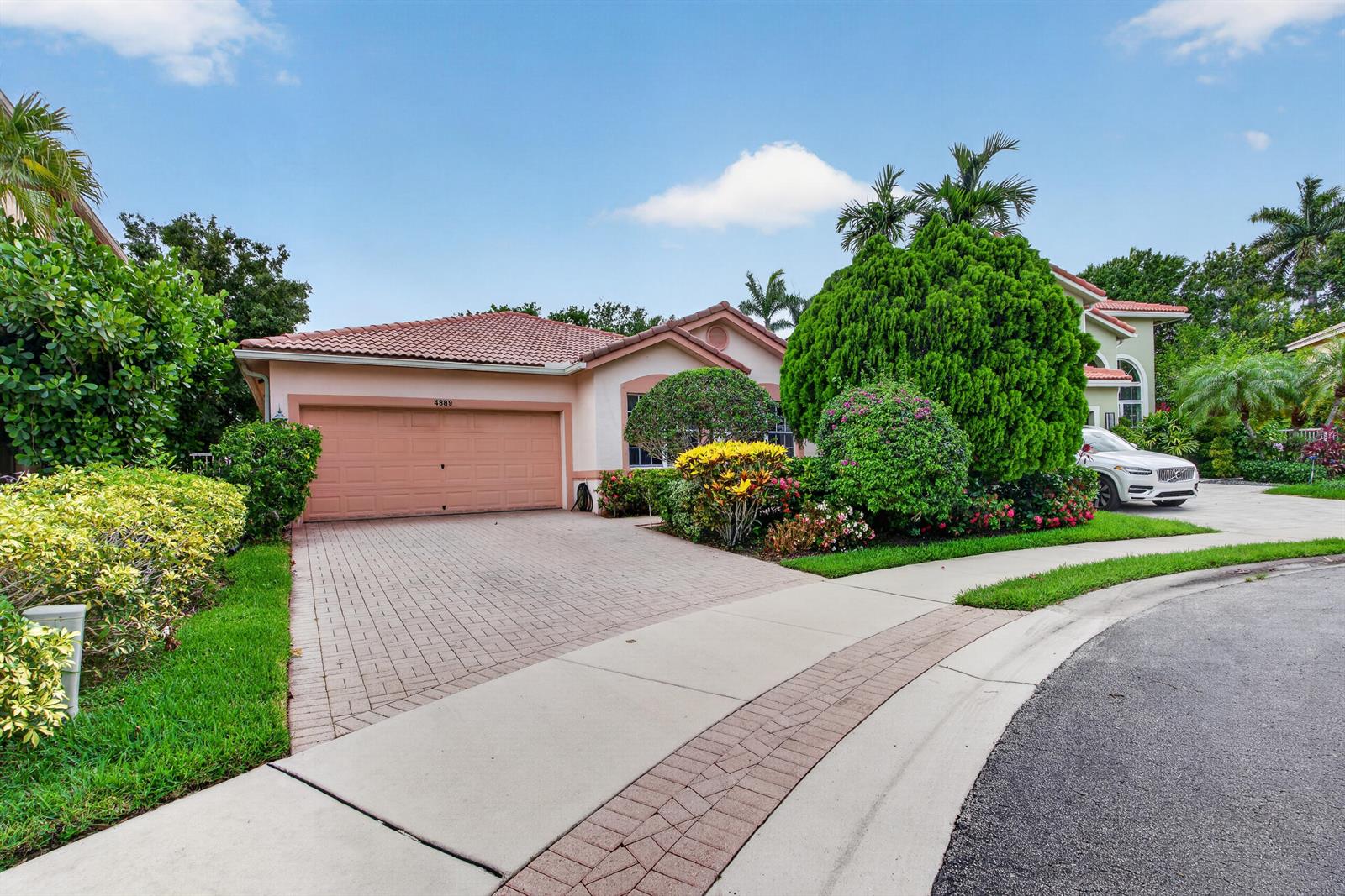 A single-story house with a peach-colored exterior, a tiled roof, and a paved driveway — 4889 N Classical Boulevard, Delray Beach FL 33445, DELRAY BEACH, FL