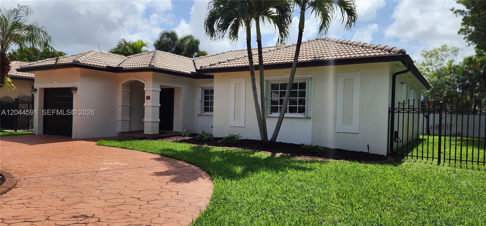 A single-story house with a tiled roof, a circular driveway, and a black metal fence — 16507 NW 91st Ave, Miami Lakes FL 33018, MIAMI LAKES, FL