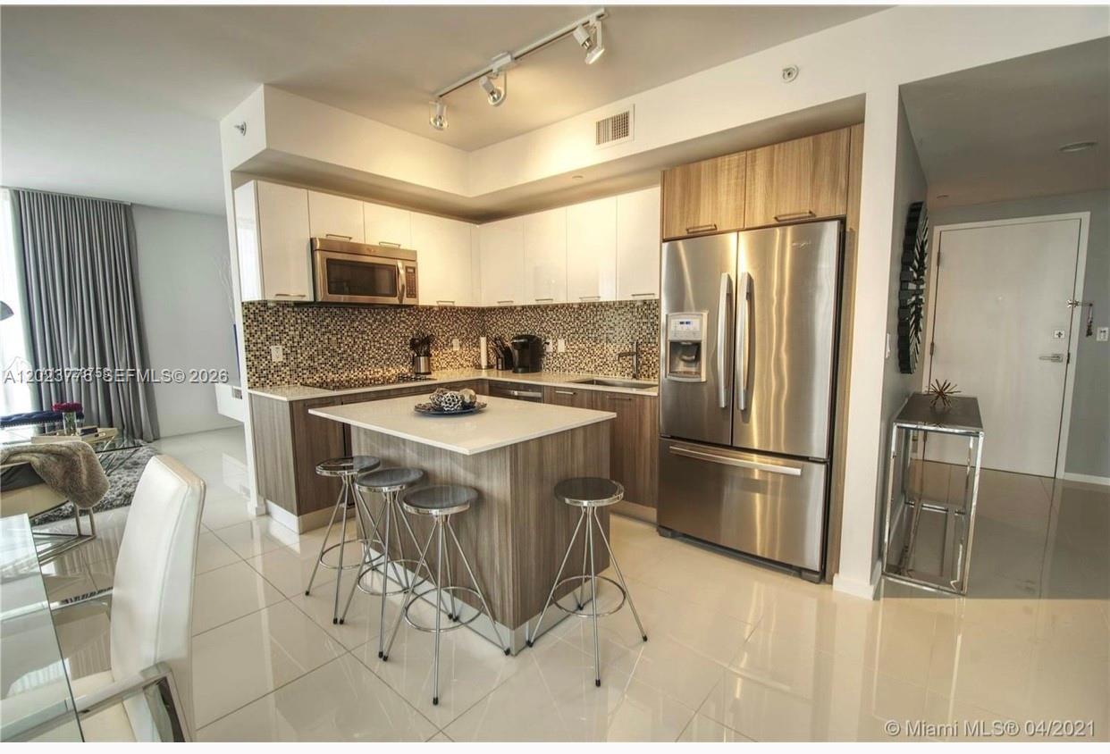 A modern kitchen features a central island, stainless steel appliances, and two-toned cabinetry — 5300 Paseo Blvd   Unit 401 # 401, Doral FL 33166, DORAL, FL