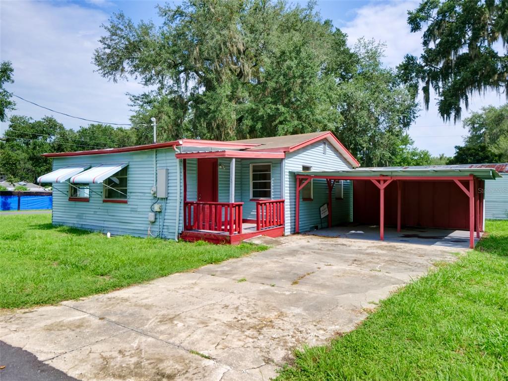 A light blue single-story house with a red porch and an attached carport — 813 NW 5TH STREET, WEBSTER, FL