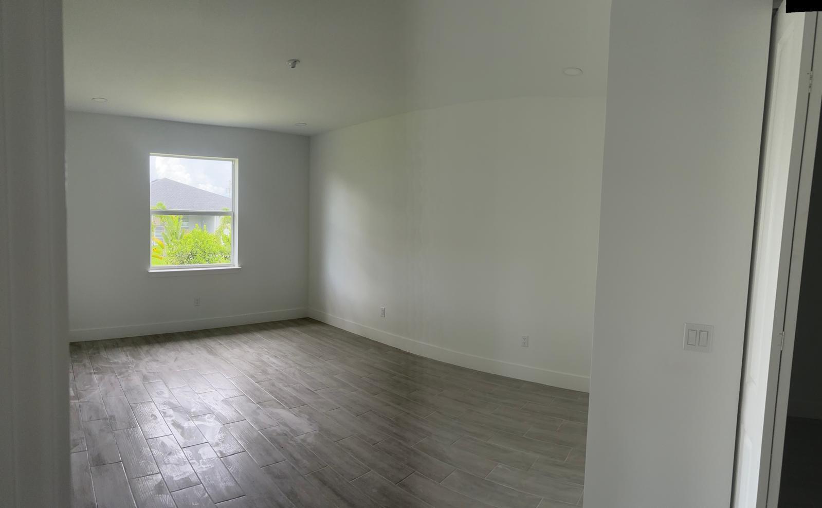 An empty bedroom features white walls, gray wood-look tile flooring, and a single window — 136 Lomas Rd Road, FL 33947, FL