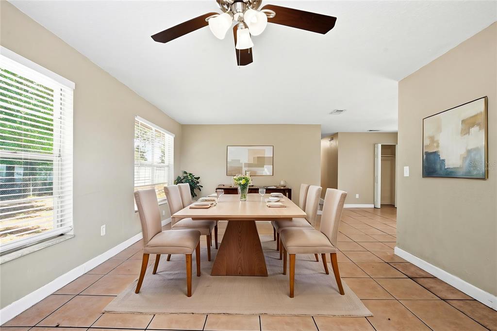 A dining room features a wooden table with six chairs, tile flooring, and a ceiling fan — 1729 FLORES COURT, ORLANDO, FL