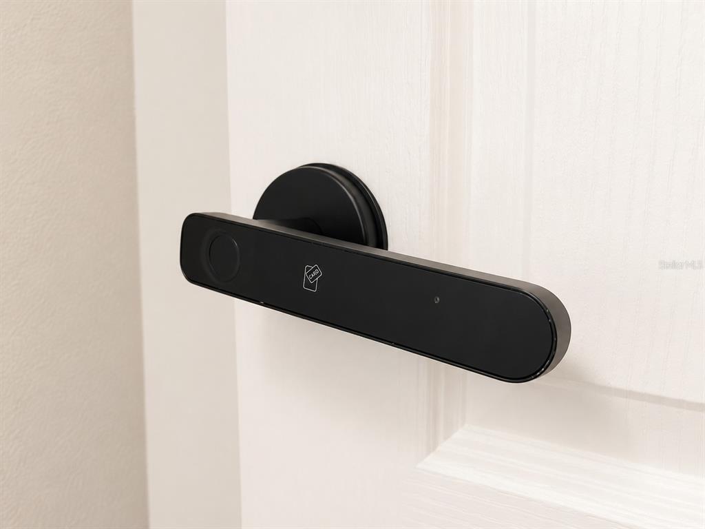 A modern black smart door handle is mounted on a white interior door — 3419 ISLEWOOD COURT, OCOEE, FL