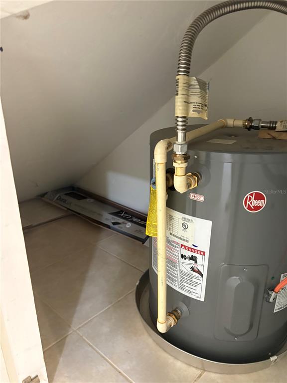 A Rheem water heater sits in a tiled utility closet under a sloped ceiling — 4624 SW 45 LANE, GAINESVILLE, FL