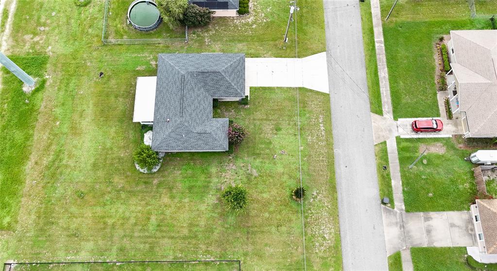 An aerial view shows a single-story house with a gray roof, driveway, and large yard — 604 BOITNOTT LANE, BUSHNELL, FL