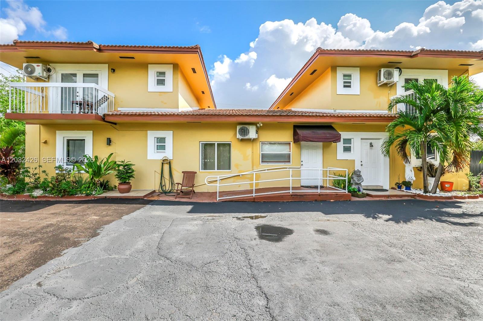 A two-story yellow building features a wheelchair ramp, balconies, and a paved parking lot — 12085 W Dixie Highway, Biscayne Park FL 33161, BISCAYNE PARK, FL