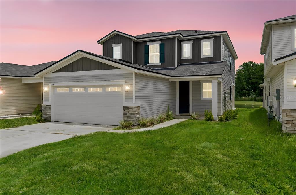 A two-story house with gray horizontal siding, a two-car garage, and a dark shingled roof — 8268 MARIETTA STILL DRIVE, JACKSONVILLE, FL