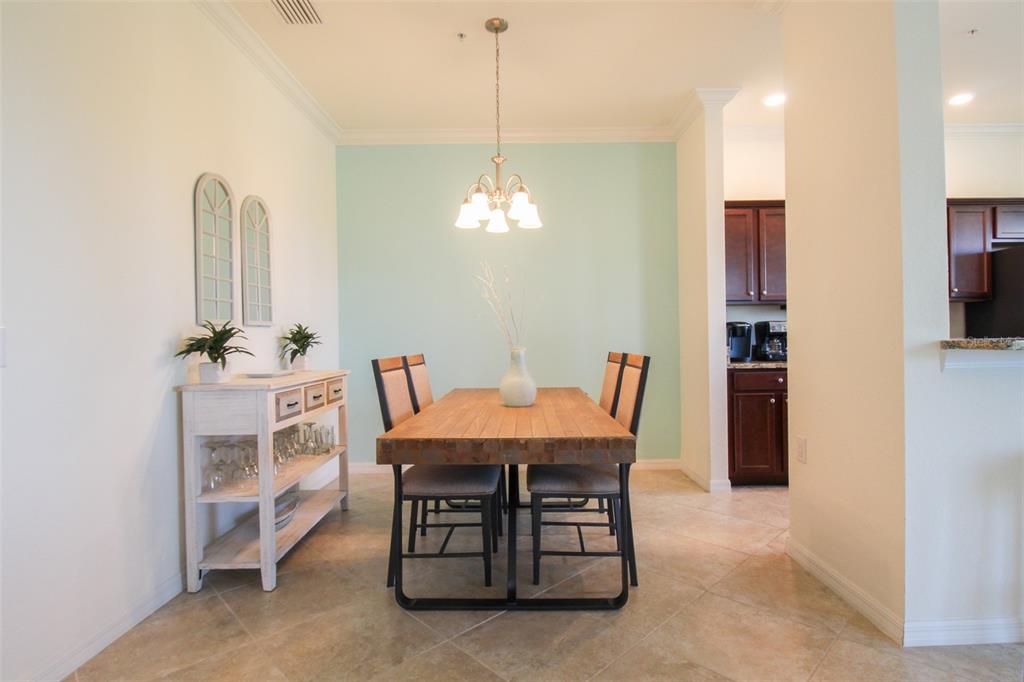 A dining room features a wooden table, four chairs, a light blue wall, and tile flooring — 16706 VARDON TERRACE UNIT 405, BRADENTON, FL