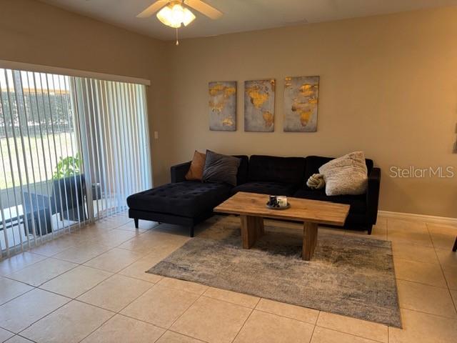 A living room features a black sectional sofa, a wooden coffee table, and wall art — 222 BEXLEY DRIVE, DAVENPORT, FL