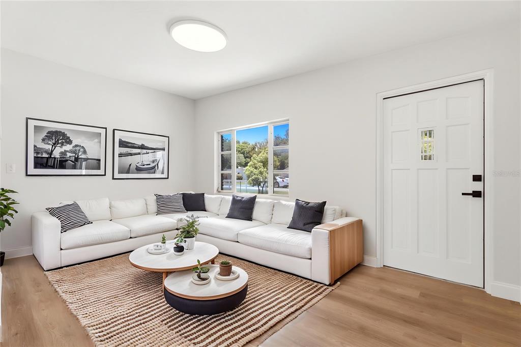 A living room features a white sectional sofa, two round coffee tables, and light flooring — 1300 MORNINGSIDE STREET, MOUNT DORA, FL