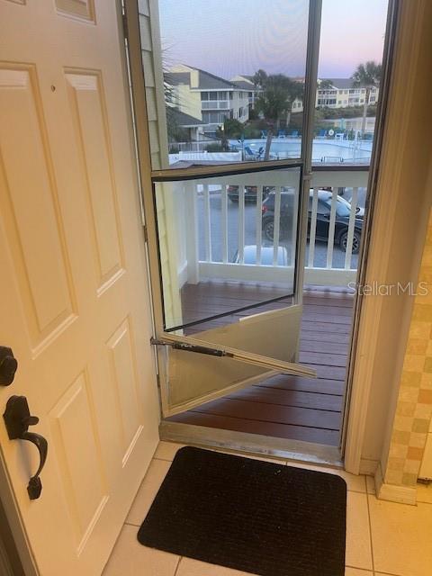 An open door reveals a screen door leading to a balcony overlooking a swimming pool — 901 OCEAN MARINA DRIVE UNIT 901, FLAGLER BEACH, FL