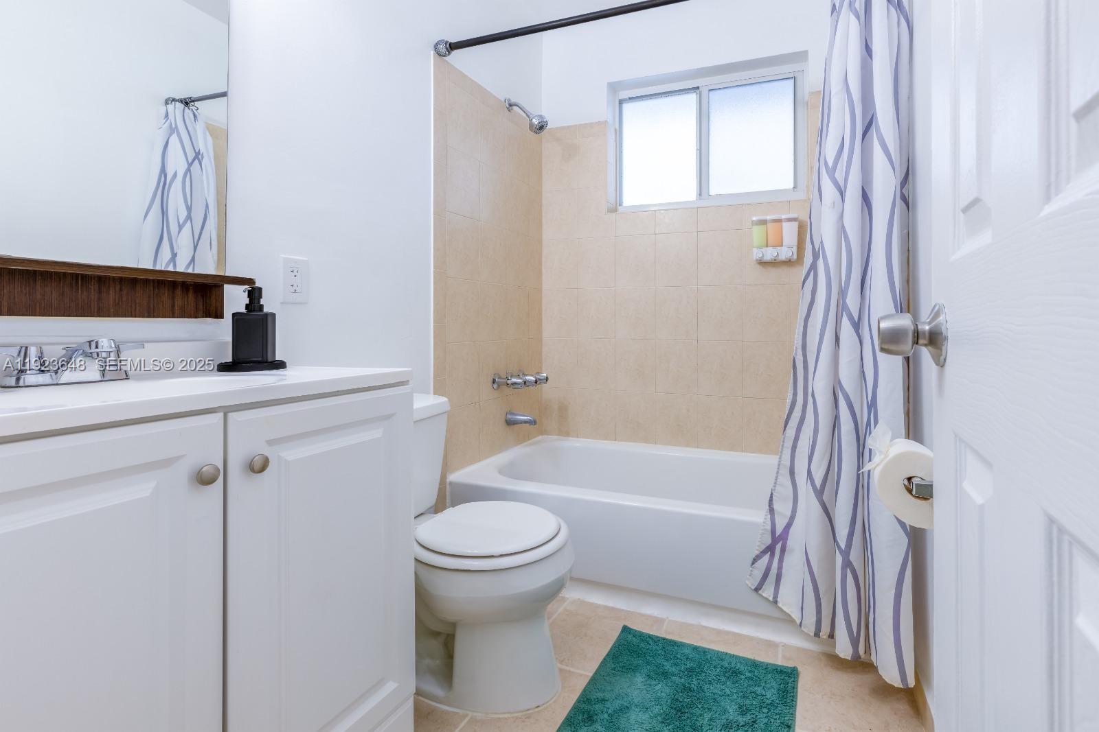A bathroom features a white vanity, a toilet, and a bathtub with beige tiled walls — 828 SW 2nd St # 2, Miami FL 33130, MIAMI, FL