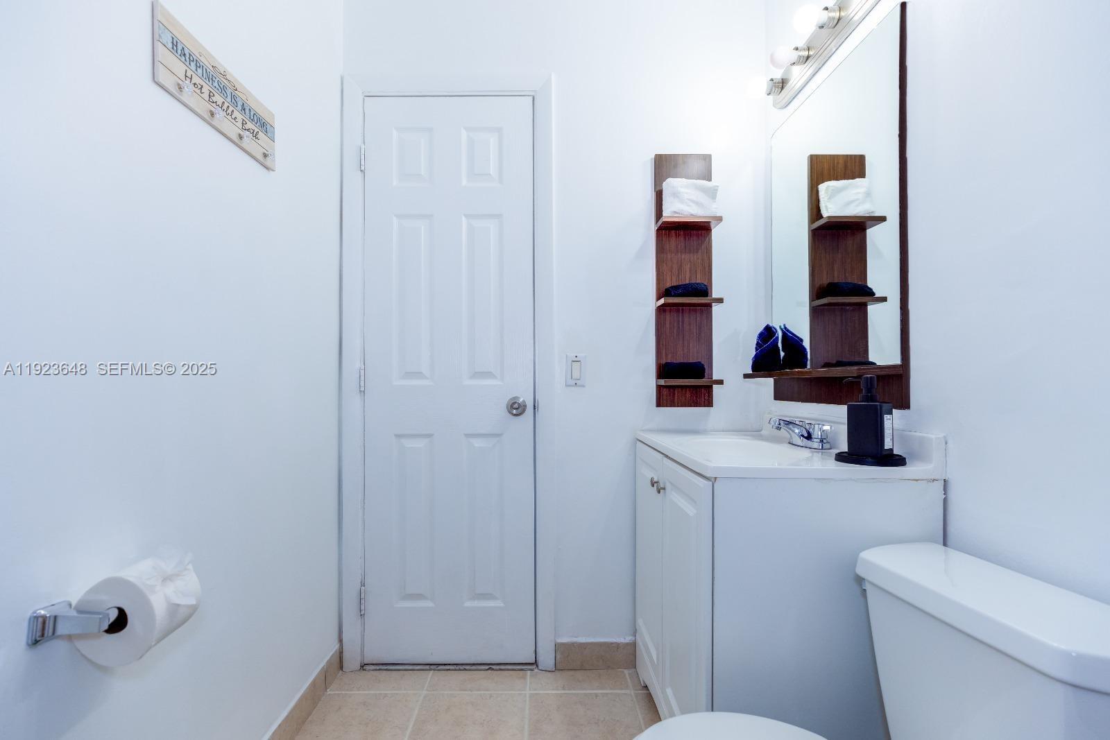 A bathroom features a white vanity, a mirror with side shelving, and a toilet — 828 SW 2nd St # 2, Miami FL 33130, MIAMI, FL