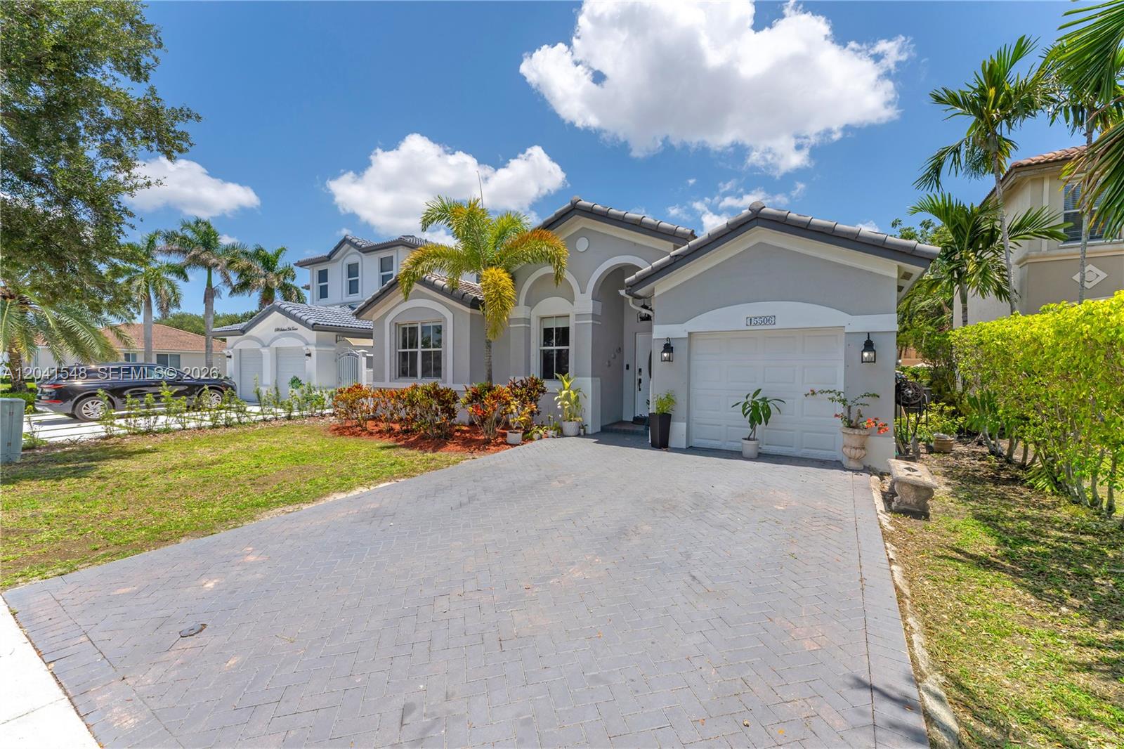 A single-story gray house with a paved driveway, a garage, and palm trees — 15506 SW 25th Ter, Miami FL 33185, MIAMI, FL