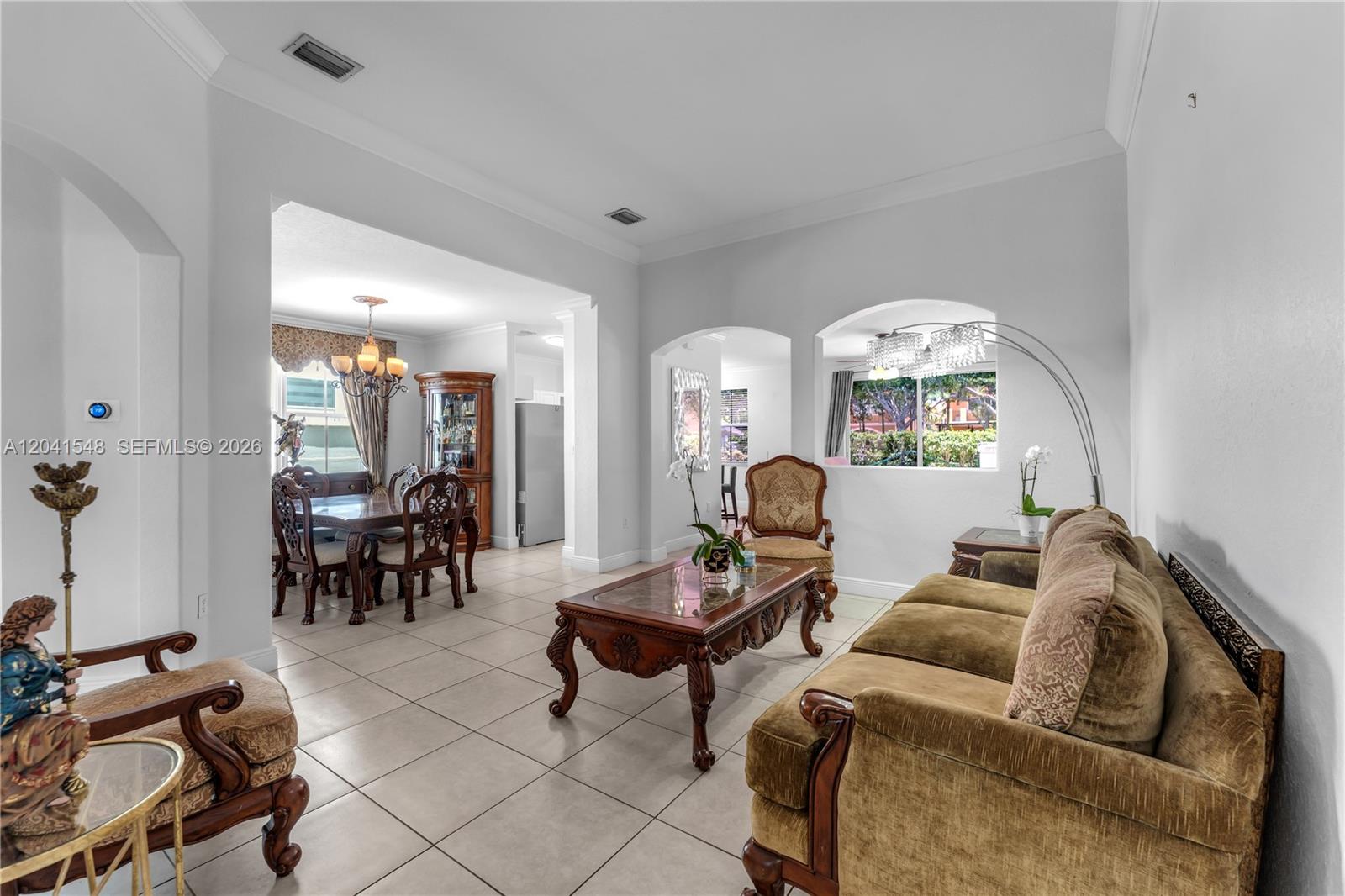 A living room and dining area with tile floors, traditional furniture, and arched wall openings — 15506 SW 25th Ter, Miami FL 33185, MIAMI, FL