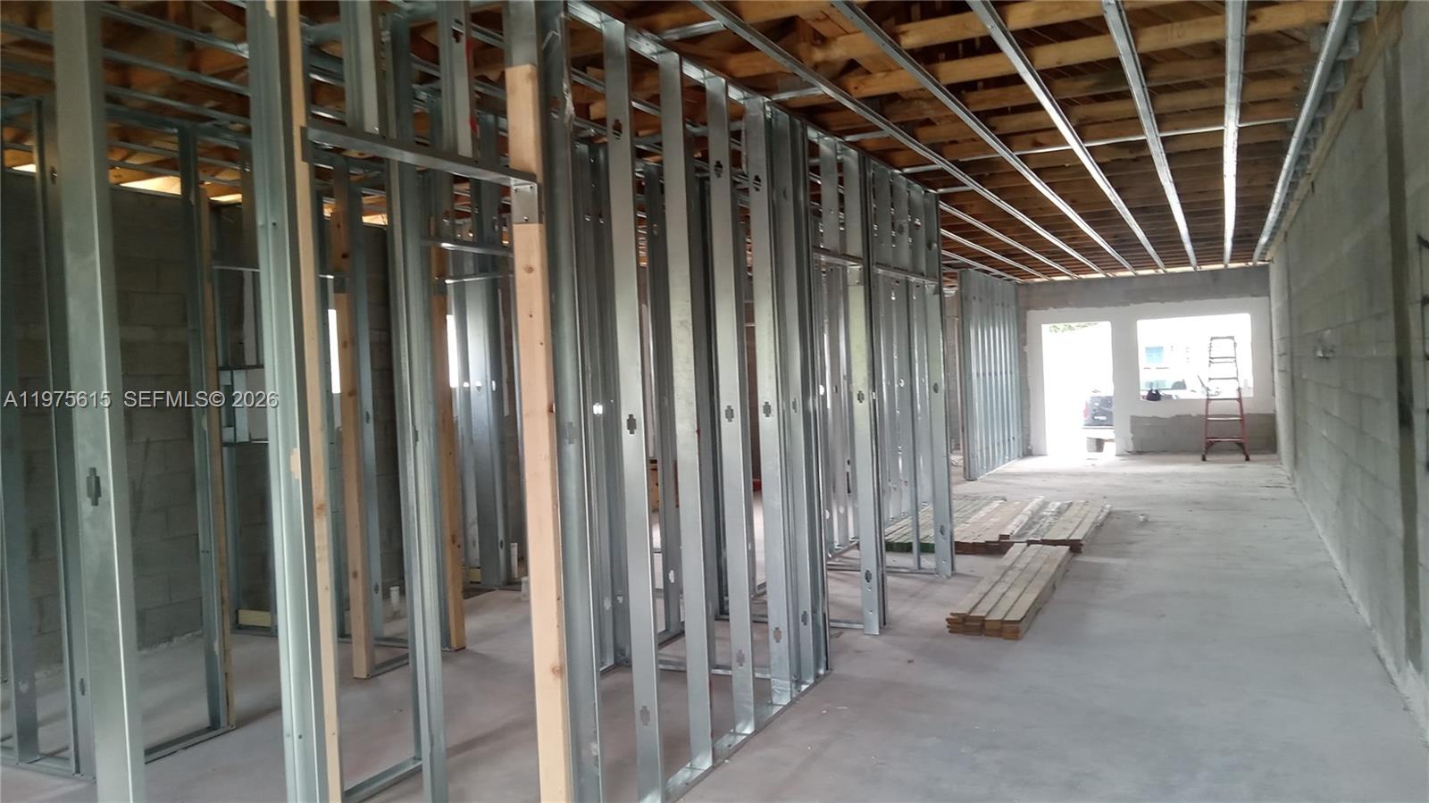 An interior view shows a construction site with metal wall framing and exposed ceiling joists — 15730 NW 38th Pl, Miami Gardens FL 33054, MIAMI GARDENS, FL