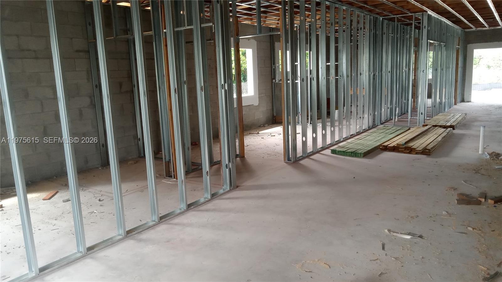 An interior view of a room under construction featuring metal wall studs and concrete floors — 15730 NW 38th Pl, Miami Gardens FL 33054, MIAMI GARDENS, FL