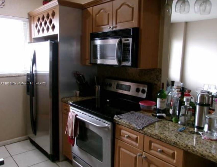 A kitchen features stainless steel appliances, wood cabinets, and granite countertops — 900 SW 84th Ave # 207A, Miami FL 33144, MIAMI, FL