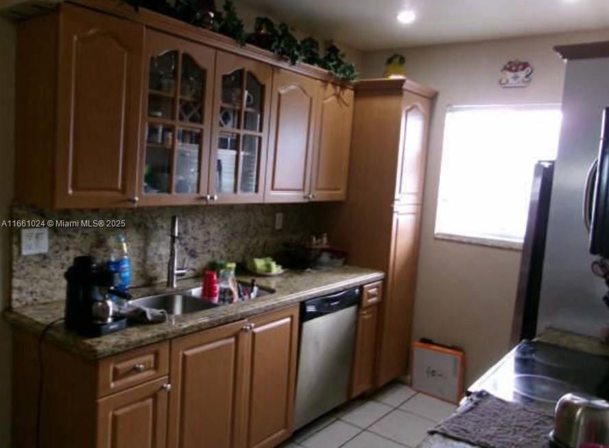 A kitchen features wood cabinets, granite countertops, a stainless steel dishwasher, and a window — 900 SW 84th Ave # 207A, Miami FL 33144, MIAMI, FL