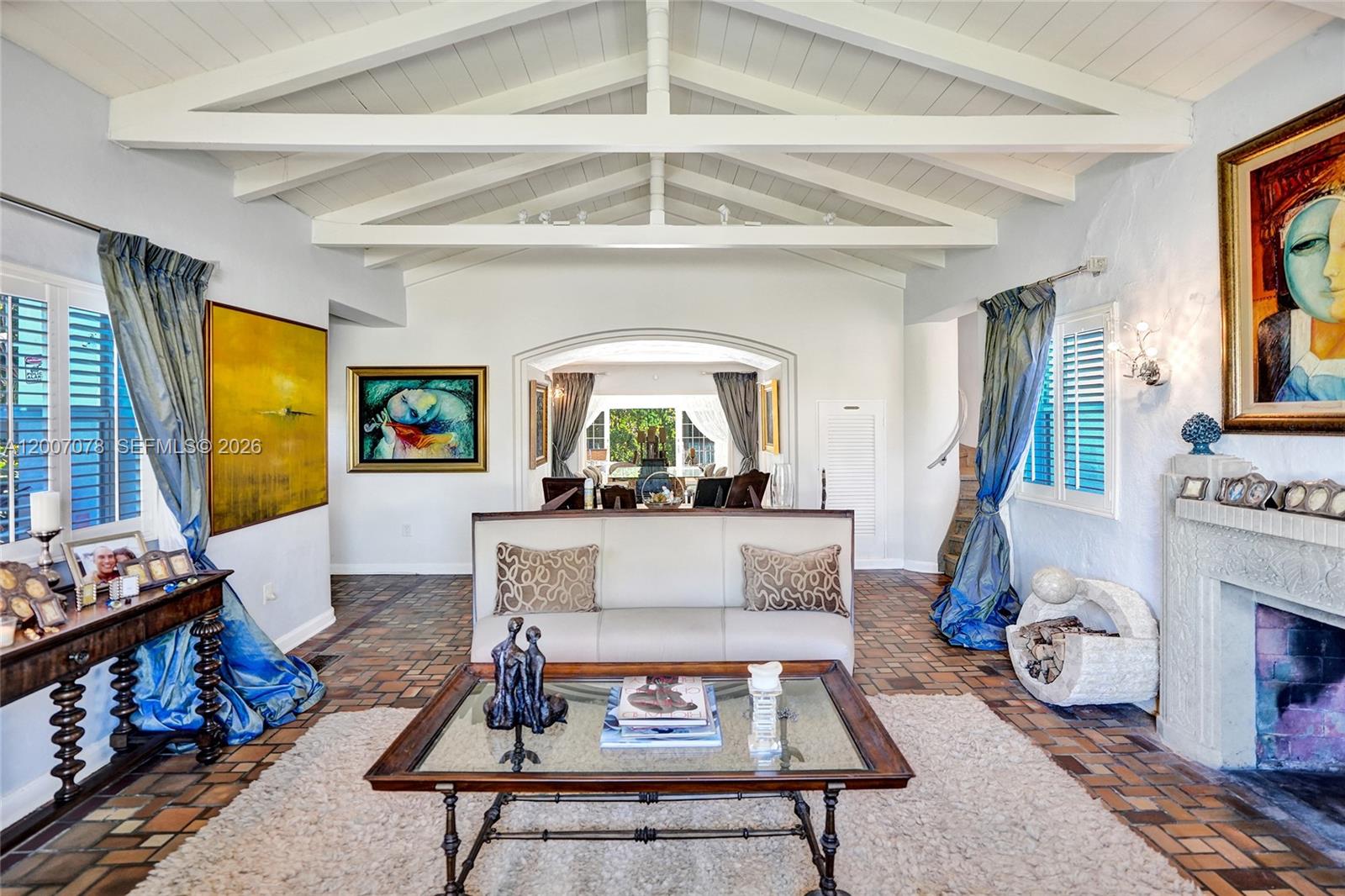 A living room features a vaulted beamed ceiling, tile floors, a fireplace, and artwork — 940 Hollywood Blvd, Hollywood FL 33019, HOLLYWOOD, FL