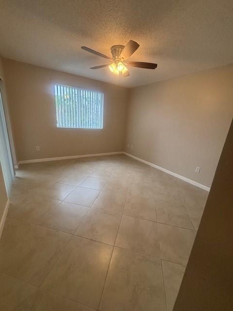 An empty room features beige tile flooring, light-colored walls, and a ceiling fan — 2640 S University Drive # 305, Davie FL 33328, DAVIE, FL