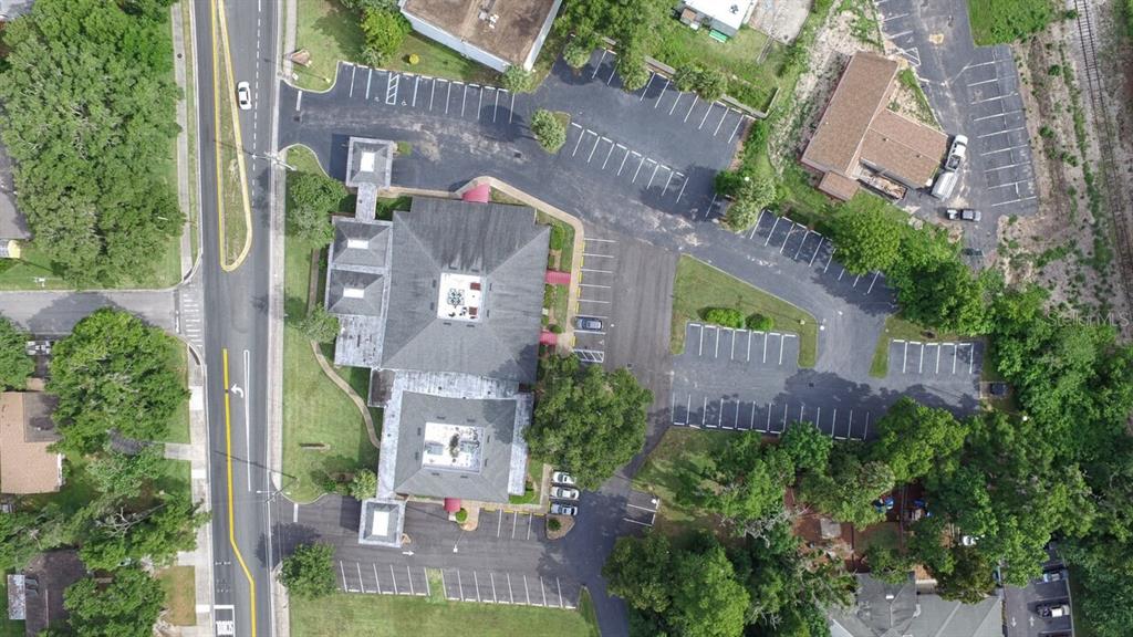 An aerial view shows a commercial building with parking lots, surrounding trees, and a nearby road — 1805 SE LAKE WEIR AVENUE UNIT 3, OCALA, FL